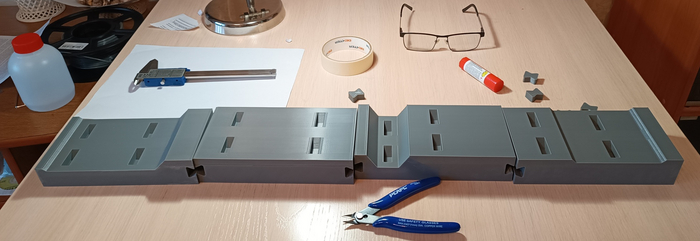 Фото основания после печати, тут видно как выглядят пазы для деталей. На фаоне очки и лист А4.