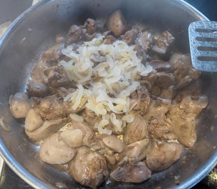 В обжаренную печень добавляем обжаренный лук, специи, воду.