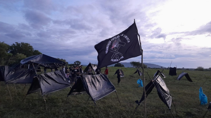 Развевающееся над временным лагерем знамя организации «Terra Liberta»