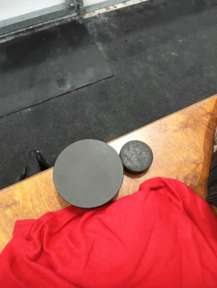 Слева шайба адаптивного хоккея для незрячих, справа - обычная для сравнения