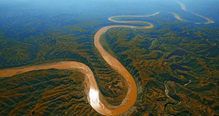 Р. Хуанхэ, буквально "Жёлтая река". Относительно спокойное течение и отсутствие порогов делает её замечательной для древнего судоходства. Обратите внимание на скалистость окружающей равнины.