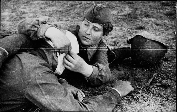 Санитарка перевязывает раненного из 237-й стрелковой дивизии