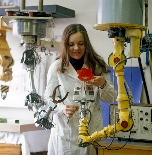 A girl laboratory assistant checks the work of robots created at a Soviet research institute. Leningrad. THE USSR. 1976 - the USSR, 70th, Girls, Robot, Robotics, Robotization, Made in USSR