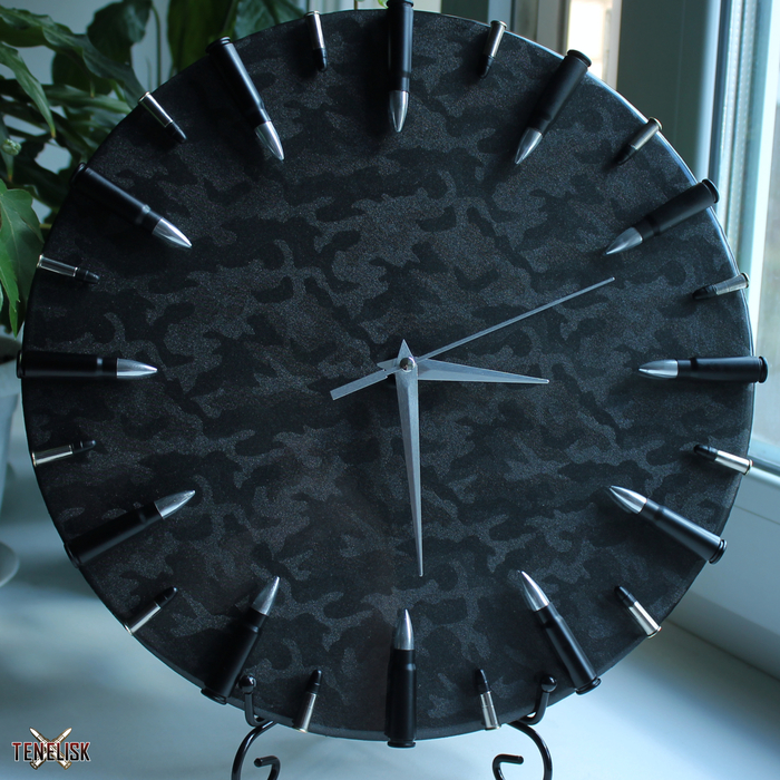 Часы оснащены кварцевым, бесшумным механизмом с плавным ходом и работают от батарейки АА. Металлические стрелки. Циферблат - окраска камуфляж(переливается при разных углах обзора), диаметром - 30 см. Гильзы калибра 7,62 и .22 LR