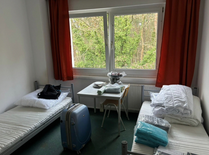 "Живем сейчас в маленьком общежитии, комнатка — как купе в поезде. Столик, холодильник".