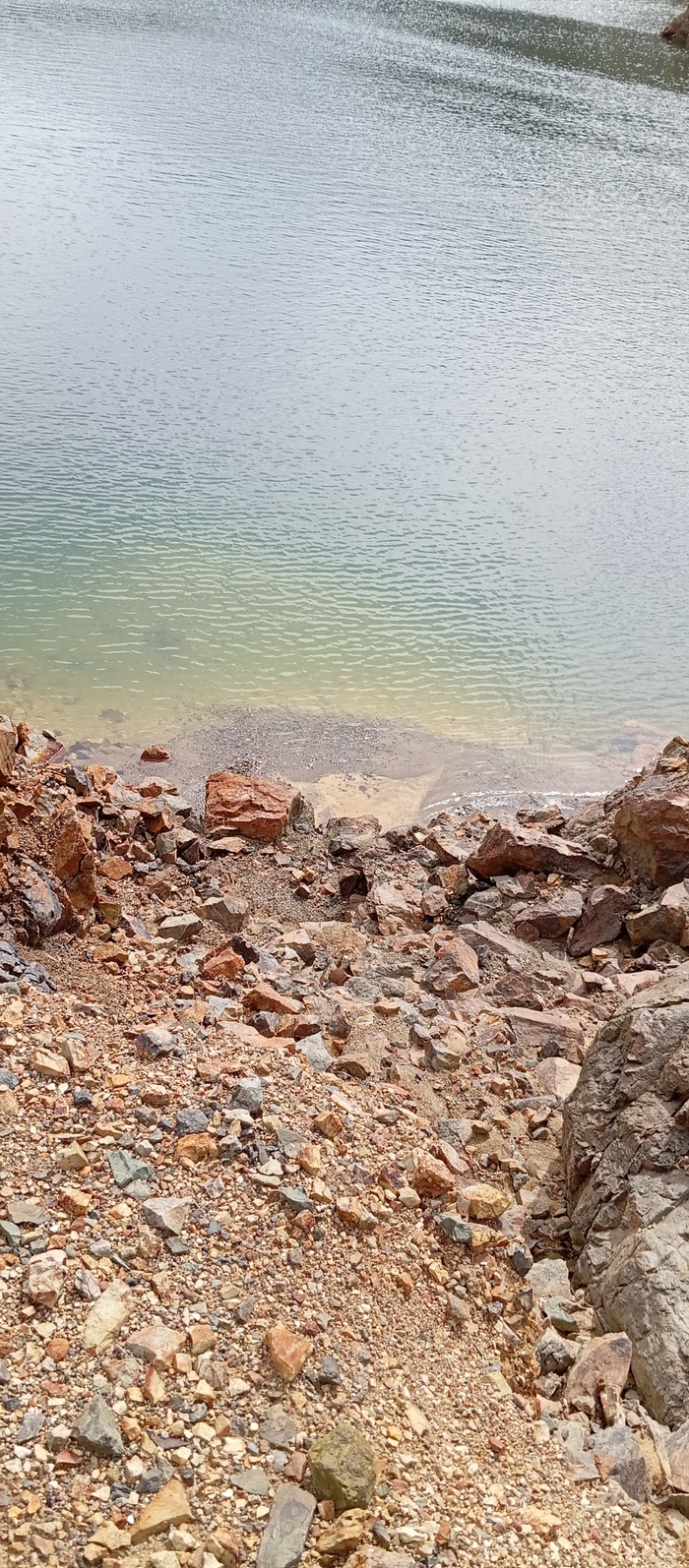 В близи вода очень даже прозрачная. Можно наглядно увидеть генезис россыпного месторождения - тяжёлый материал осаждается в месте снижения скорости потока воды, а лёгкие частицы уносятся дальше. Виден намытый шлейф плотных пород и направление струй.