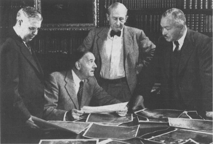 Милтон Л. Хьюмасон, Эдвин Хаббл, Вальтер Бааде и Рудольф Минковский изучают фотографии, сделанные с помощью 48-дюймового телескопа Шмидта в Паломарской обсерватории. Библиотека обсерватории Карнеги, 1950 г. (Credit: Гамбургская обсерватория).