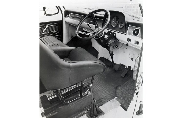 Выглядит почти как кабина обыкновенного фургончика Ford Transit... Если бы не кресло-«ковш», гоночный руль, размеченный до 8000 об/мин тахометр и рычаг коробки передач у правой двери