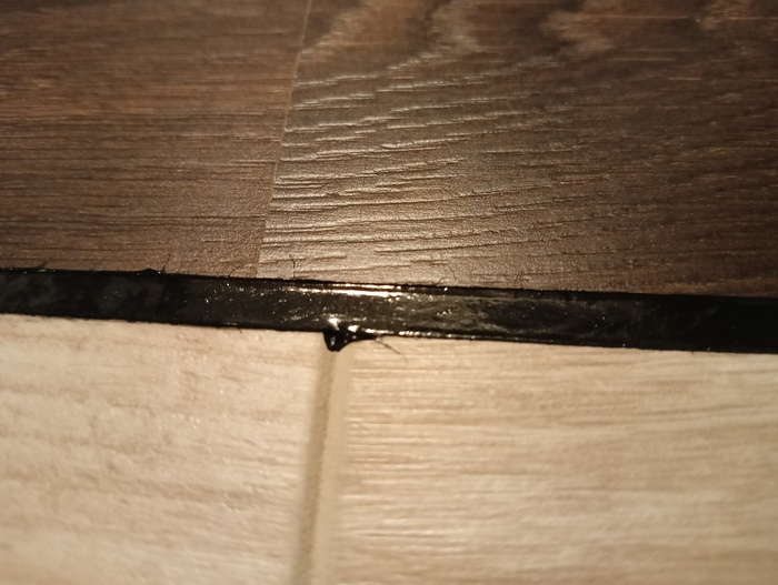 Герметик затёк в фаску ламината, издалека почти незаметно.