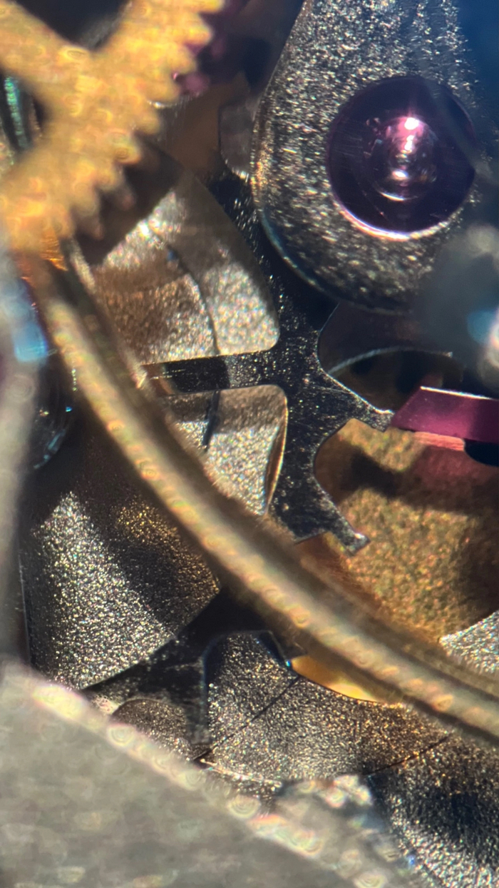 Анкетное колесо и палеты анкерной вилки (розовые рубиновые камни) со следами старой смазки и грязью на палетах