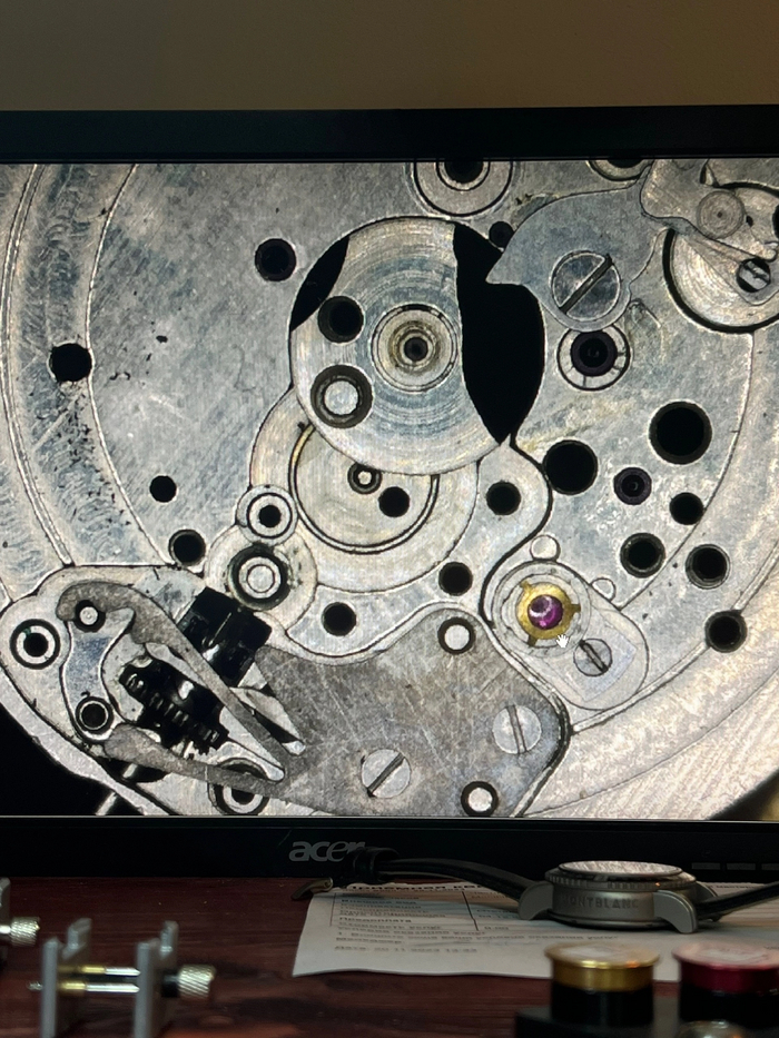 Основная платина часов на которой происходит сборка всего механизма, на фото не разобран ремонтуар, не снят толкатель даты и не сняты накладные бушоны. Но все равно уже видны следы мелкого мусора на посадочном месте календарного диска и грязь на стойках