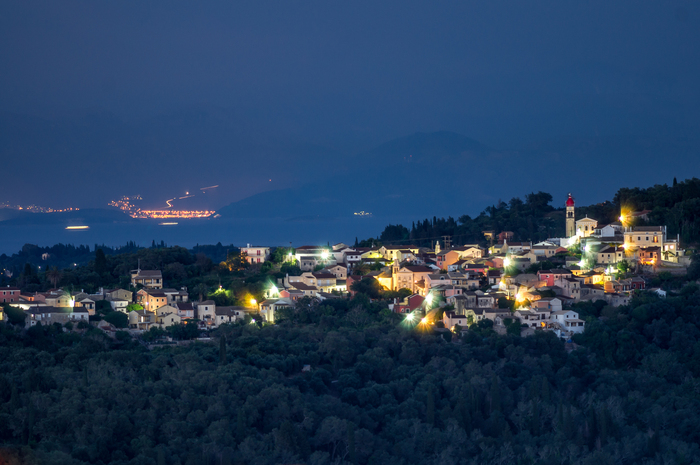 Деревня Варипатадес. Позади просматриваются холмы уже материковой Греции. Ярко светящаяся полоса - порт Игуменица.
