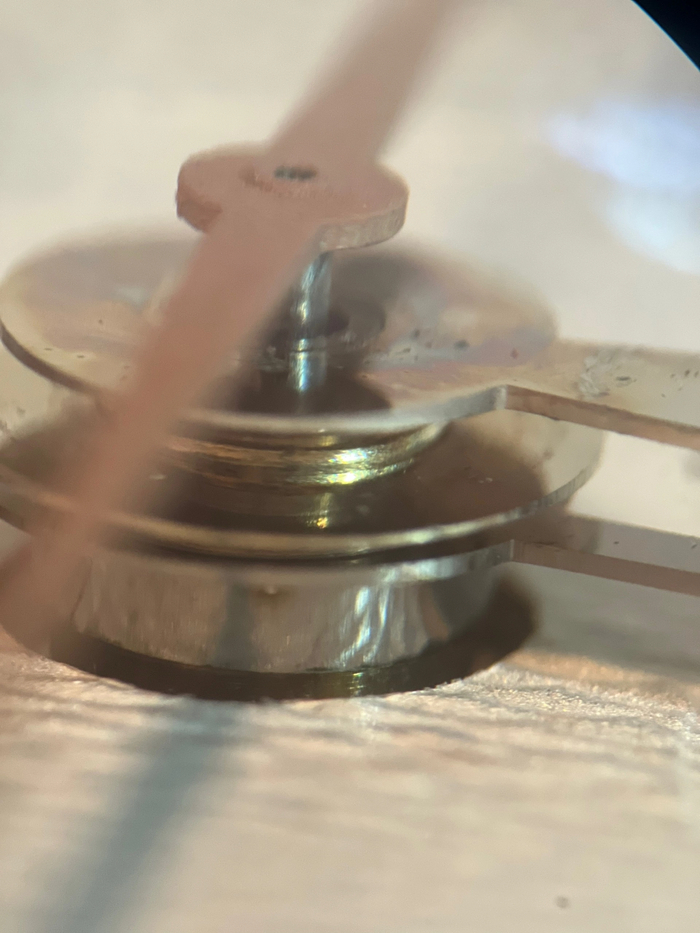 Мелкий сор + радужные следы на стрелках часов, явный результат попадания влаги