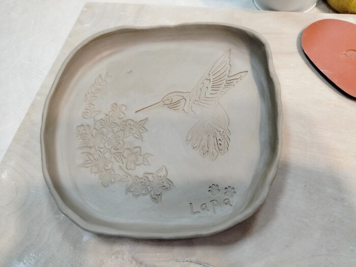 Тарелка из глины квадратной формы с рисунком букета цветов и порхающей колибри.