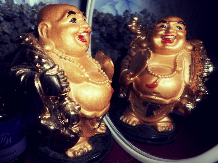 Золотой мужик смотрит на себя в зеркало