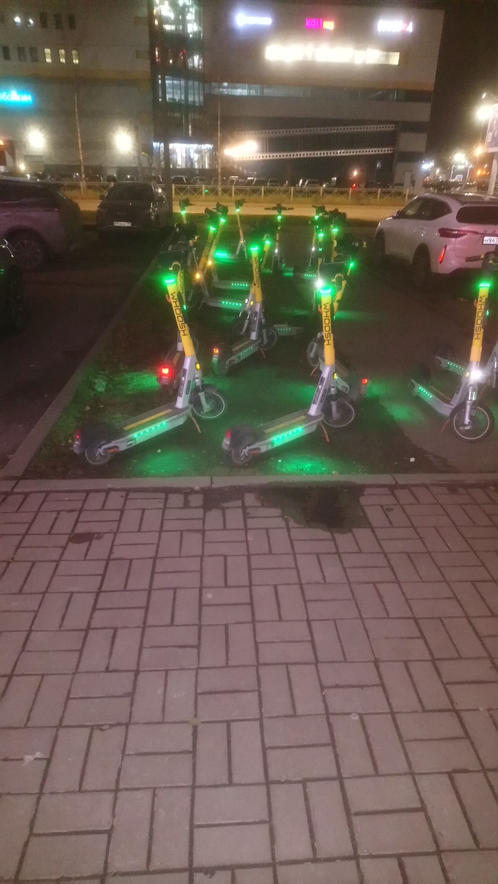 Самокаты на выпасе или на пастбище.... Просто тротуар и часть газона, ну был газон, пока самокаты не пришли пастись