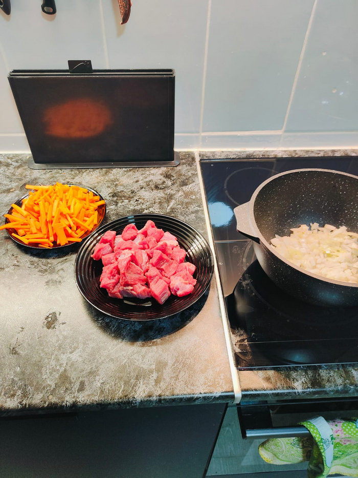 Готовлю овощи и мясо. Морковь брусочками, лук средне, мясо кубиком Лук ставлю жарится.