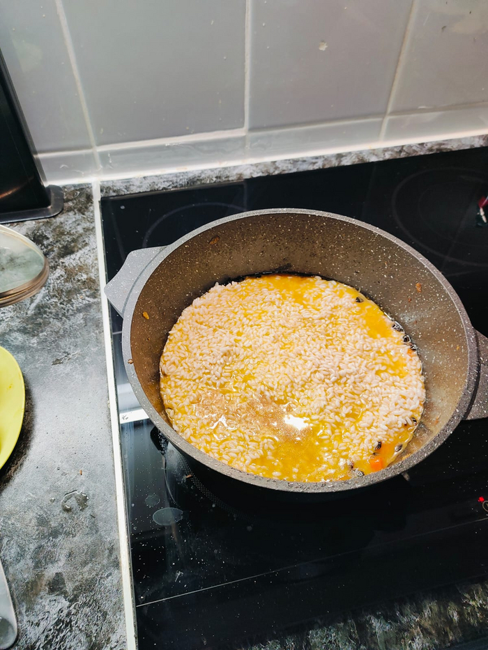 Как только зирвак готов, всыпаю рис и разравниваю. Чеснок вынимаю