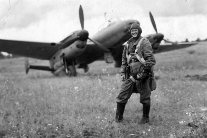 Воздушный стрелок-радист 2-й эскадрильи 58-го бомбардировочного авиационного полка 6-й воздушной армии Северо-Западного фронта ефрейтор Мария Константиновна Малькова на фоне бомбардировщика Пе-2.