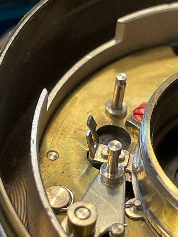 Вот эти усики погнуты, они заходят во взведенный механизм автоспуска и спуск не происходит, пока механизм не отработает.