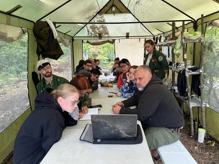 Начальник экспедиции читает лекцию на отдыхе после обеда