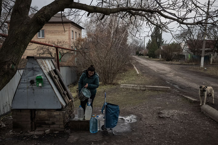 Женщина наполняет бутылки водой из колодца в деревне к северу от Покровска. (Эд Рам для The Washington Post)