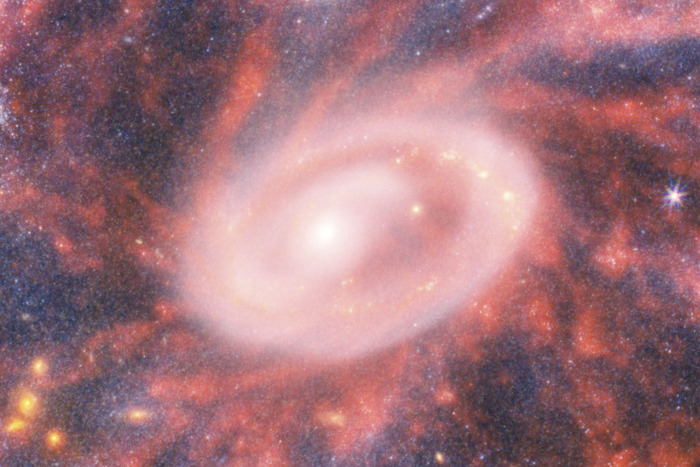 "Сердце" галактики Колесо Телеги. Сверхчувствительные инструменты "Джеймса Уэбба" позволили выявить многочисленные звездные скопления (желто-оранжевые пятна за бело-розовой "дымкой") / © NASA, ESA, CSA, STScI