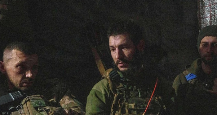 Украинские солдаты 117-й отдельной тяжелой механизированной бригады сидят в землянке после обстрела российских позиций на линии фронта в направлении Покровска