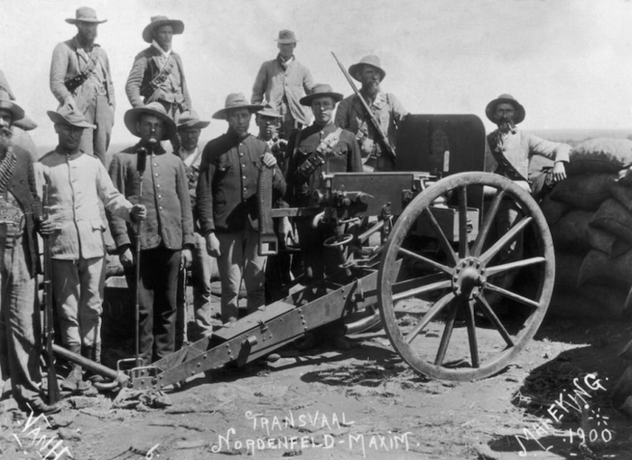 Трансваальские артиллеристы в защитной полевой, синей служебной (с нагрудными карманами) и серой "новошивной" (без карманов) униформе и ополченцы у 37-мм Максима на позициях близ Мафекинга, 1900.