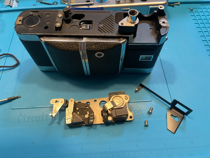 снятый узел дальномера. Черная деталька это шторка, которая двигает рамку видоискателя для компенсации параллакса. Простое и эффективное решение.