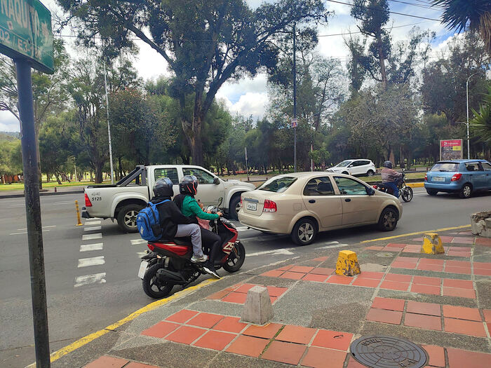 Втроем на мотоцикле в столице. Спереди сидит маленькая дочка. Обычная картина для Эквадора.