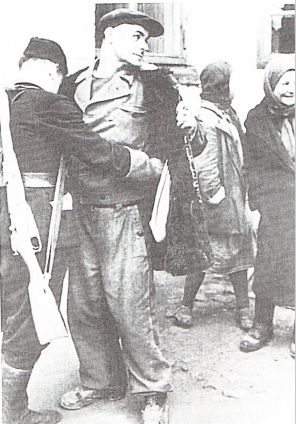 Полицейский из ОПВ обыскивает рабочего. Одет в бывшую форму Альгемайне СС. Киев 1942 год.