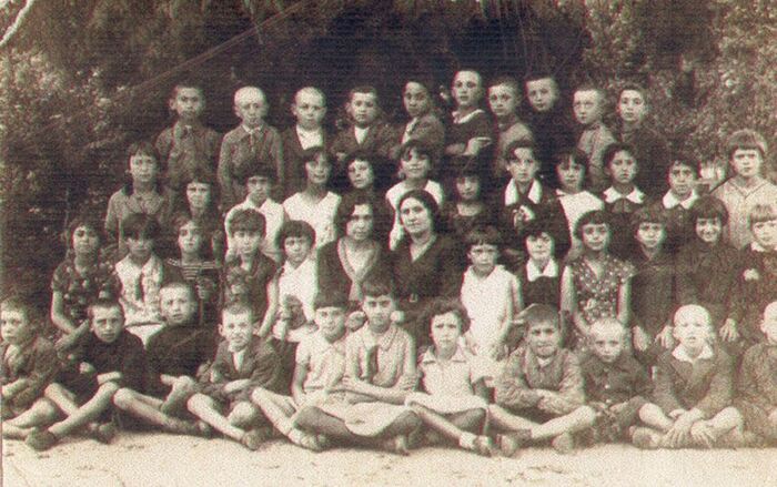 Сара - девочка в платье в горошек - во время учебы в школе.