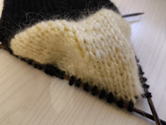 По двум боковым краям стенки пятки набираем петли чёрной нитью. Свето-лимонную нить обрезаем, кончик нити оставляем на изнанке.