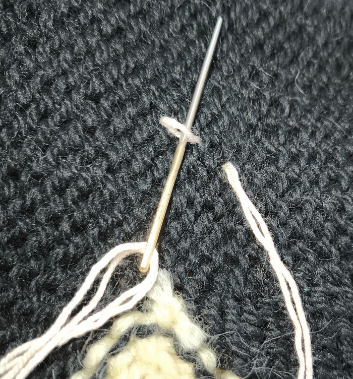 С изнанки нить закрепляем, вводя иглу в петельку на конце нити