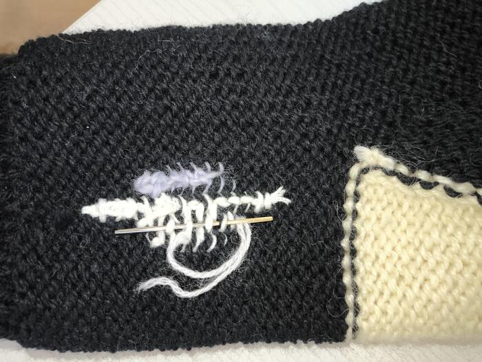 Когда нить заканчивается, иглой заправьте ее за петли вышивки и обрежьте кончик