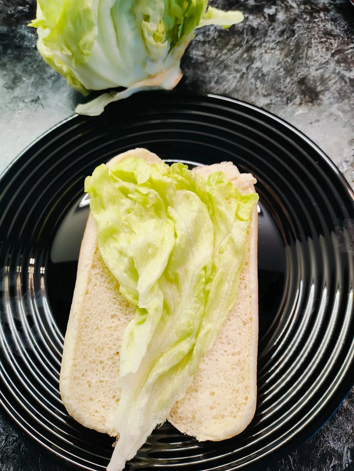 Собираю хот-дог, сначала укладываю на булочки лист салата . Хлеб не обмазывал соусами и не жарил. Потому что так хочу.