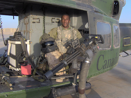 Нигра Джо с дробовиком и шлемом, стоимостью с половину вертолета. Для понимания, что нигра из Канады, можно не читать надпись на борту. У оператора - характерный, именно канадский камо как на жилете, так и на штанах. Но это уже для упоротов :)