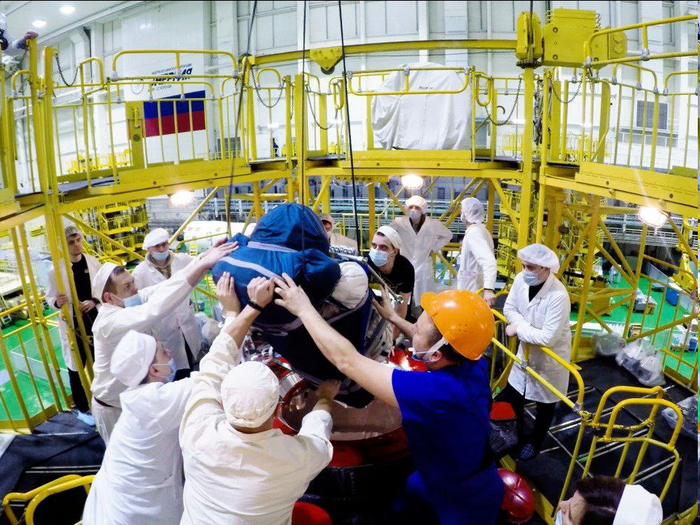 Процесс погрузки скафандра в "Прогресс". Весит он 105-110 килограммов, поэтому просто на руках аккуратно уложить в герметичный отсек корабля его сложно.