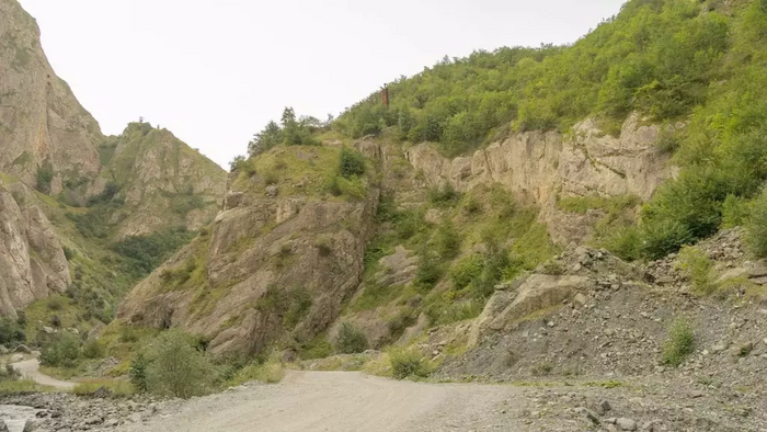 Дорога через Кармадонское ущелье и обрезок трубы, пробитой поисковиками в тоннель