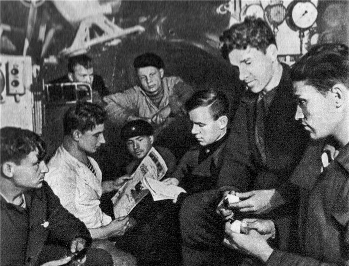 Советские подводники (К-22, Северный флот) за чтением газеты, 1941. Некоторые краснофлотцы сочетают повышение политграмоты с чисткой картошки.
